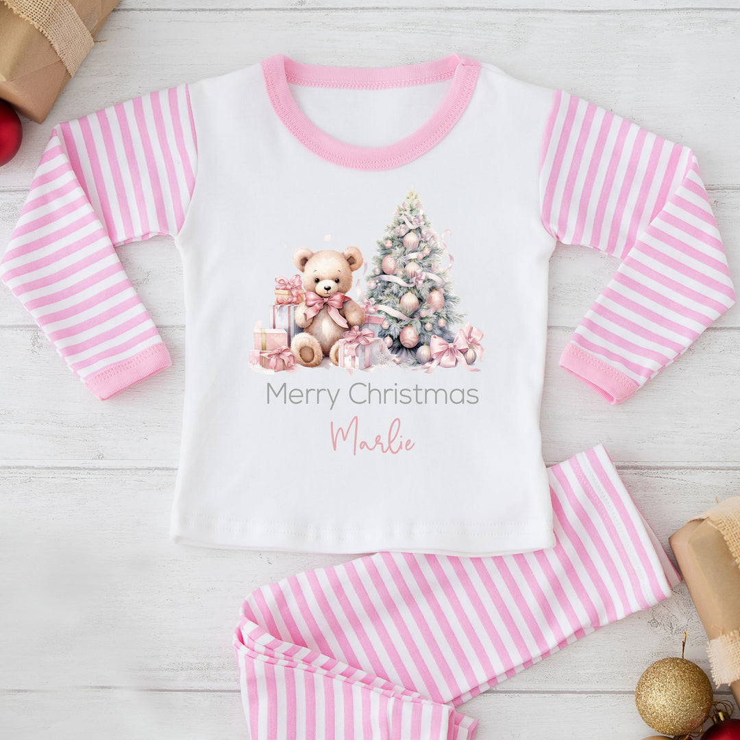 A white teddy bear and a Christmas tree with gifts, text 'Merry Christmas' and the name 'Marlo' on a pink and white striped background.