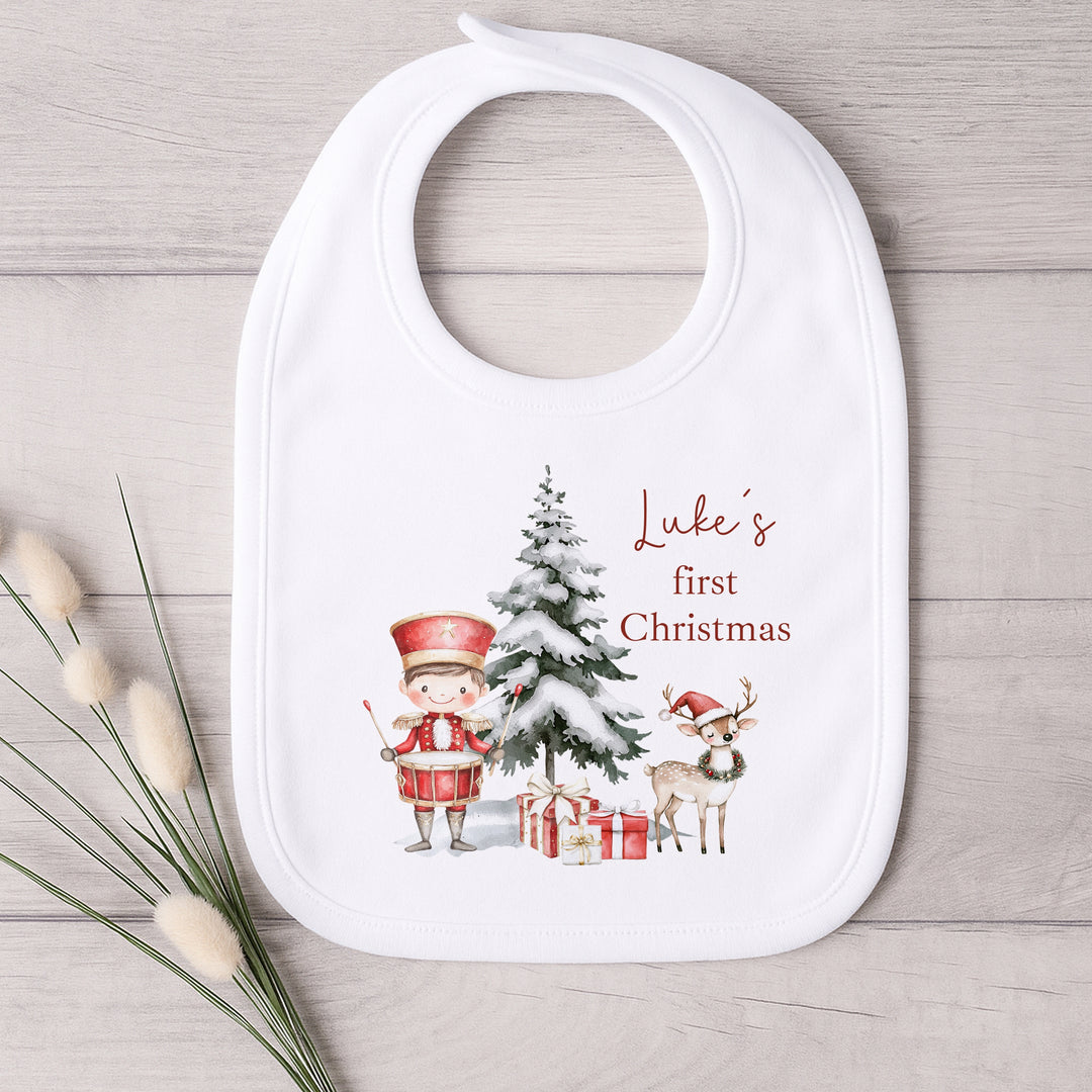 Baby bib with Christmas design and text on a wooden surface