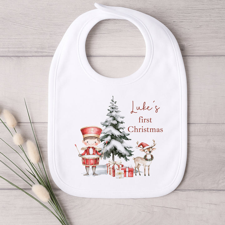 Baby bib with Christmas design and text on a wooden surface