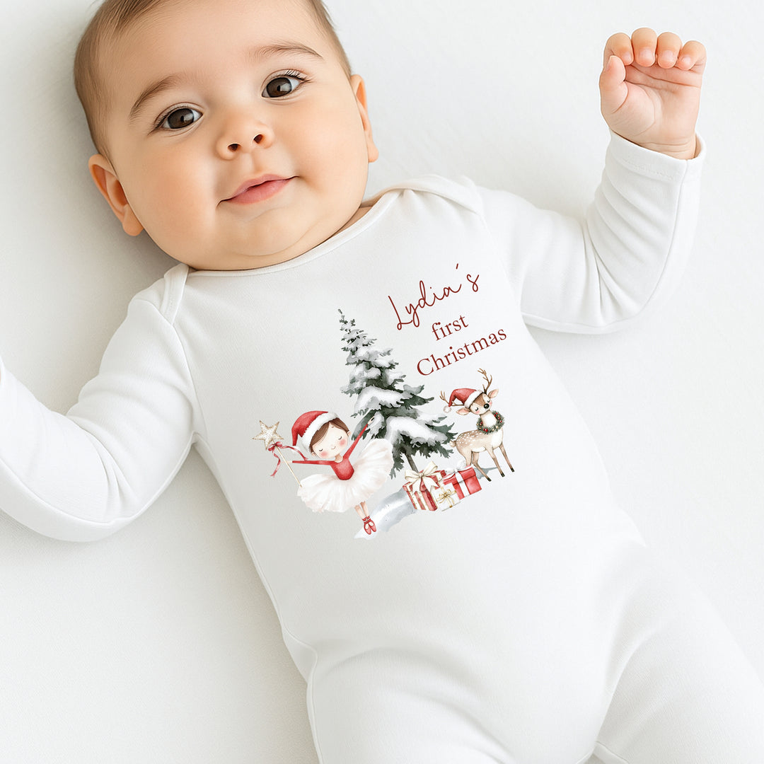 Baby wearing a white onesie with Christmas-themed design and text on a white background