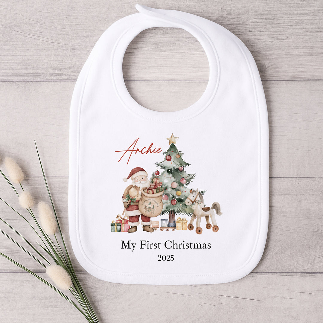 Baby bib with Christmas design and text on a wooden surface
