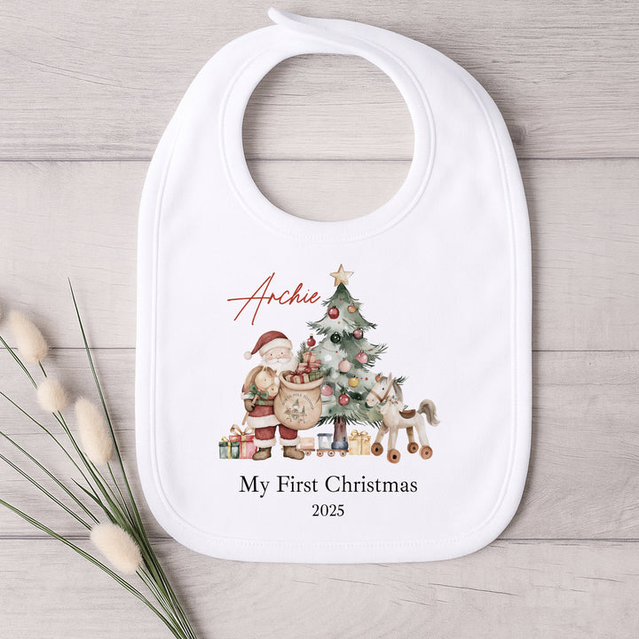 Baby bib with Christmas design and text on a wooden surface