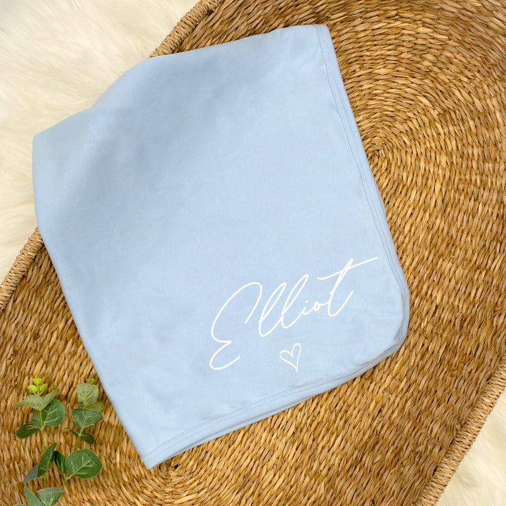 a personalised blue baby blanket that says 'Elliot'