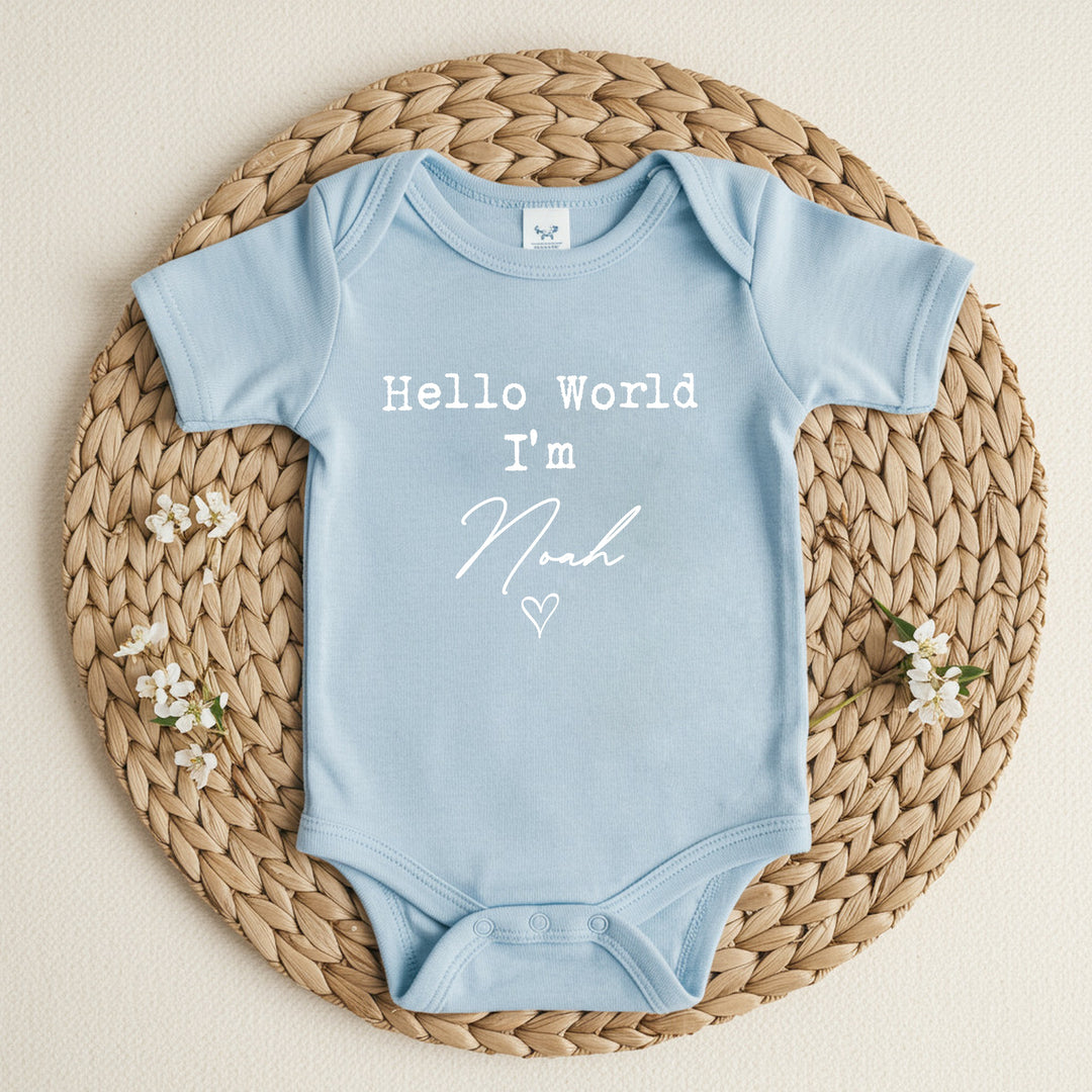 a personalised blue baby vest that says 'Hello World I'm Noah'