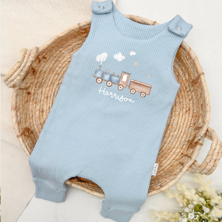 Personalised blue ribbed dungarees that say 'Harrison'. This design features a blue train