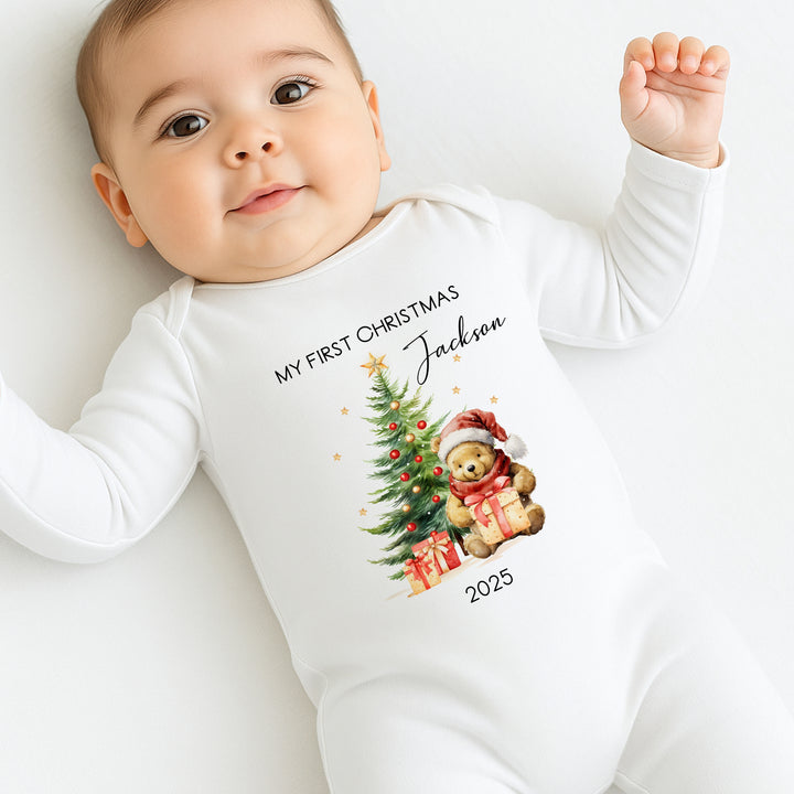 Baby wearing a white onesie with Christmas design and text