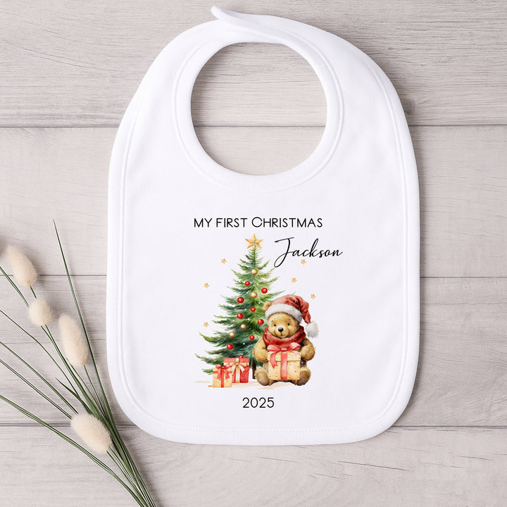 Baby bib with Christmas design and text on a wooden surface
