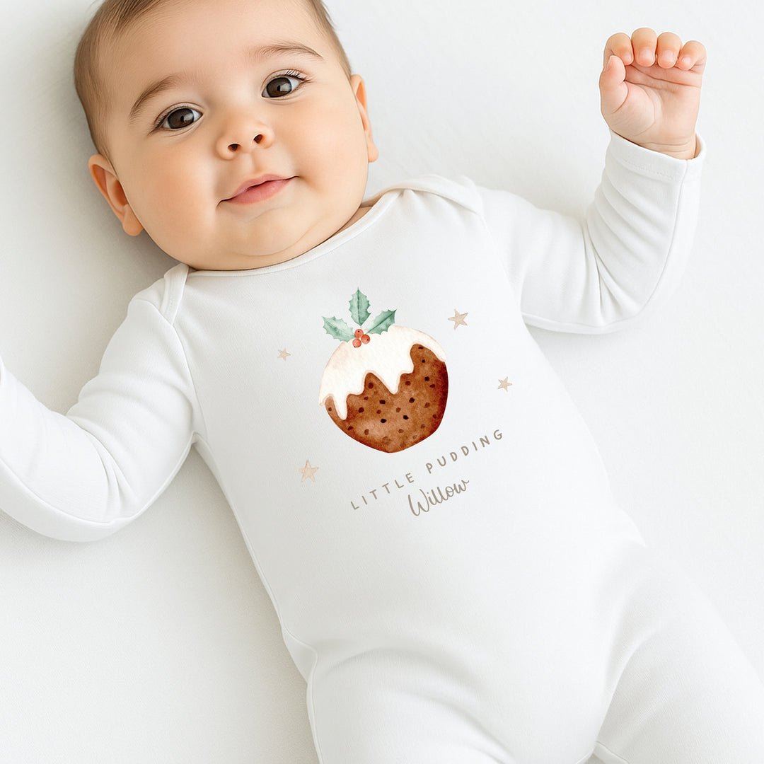 Baby wearing a white onesie with a pudding design and text on a light background