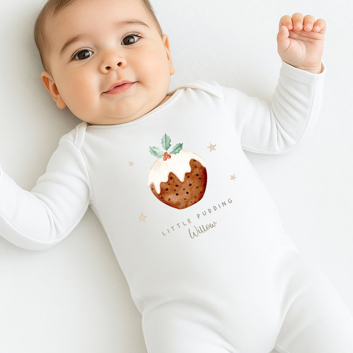 Baby wearing a white onesie with a pudding design and text on a light background