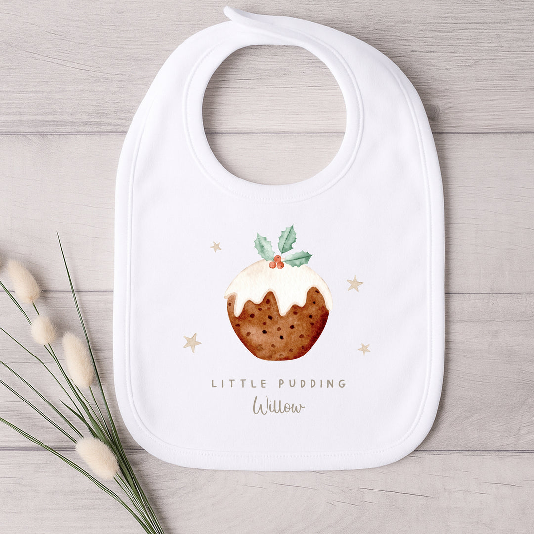 White bib with a Christmas pudding design and text on a wooden surface