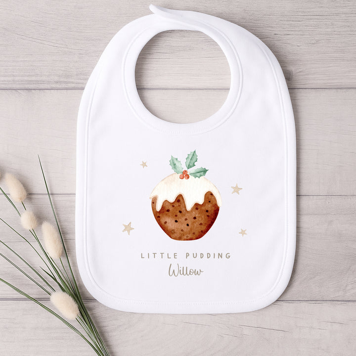 White bib with a Christmas pudding design and text on a wooden surface