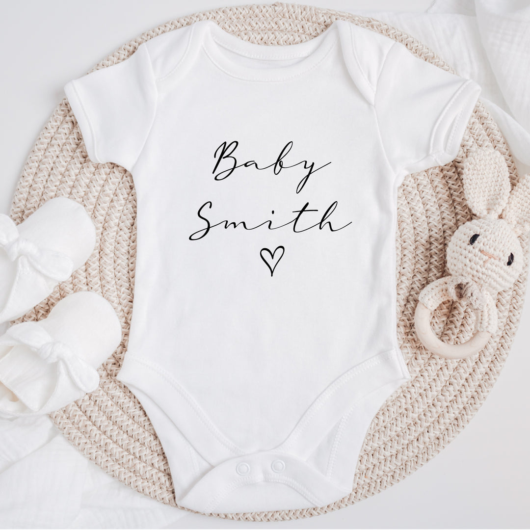 Baby announcement vests that says: Baby Smith with a heart underneath