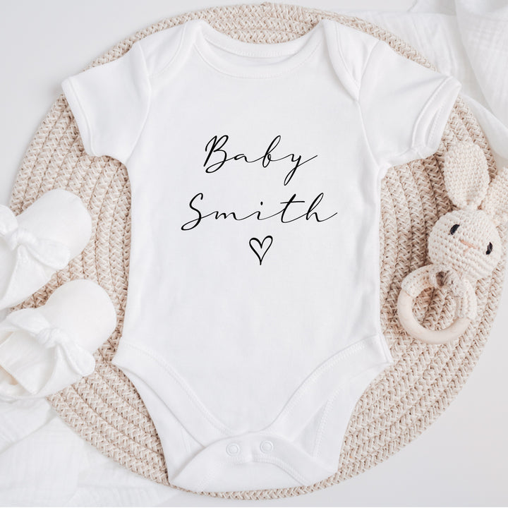 Baby announcement vests that says: Baby Smith with a heart underneath