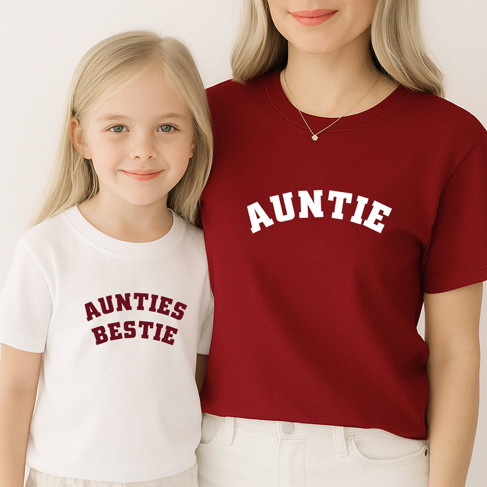 Two people wearing shirts with 'AUNTIE' and 'AUNTIES BESTIE' text on a plain background