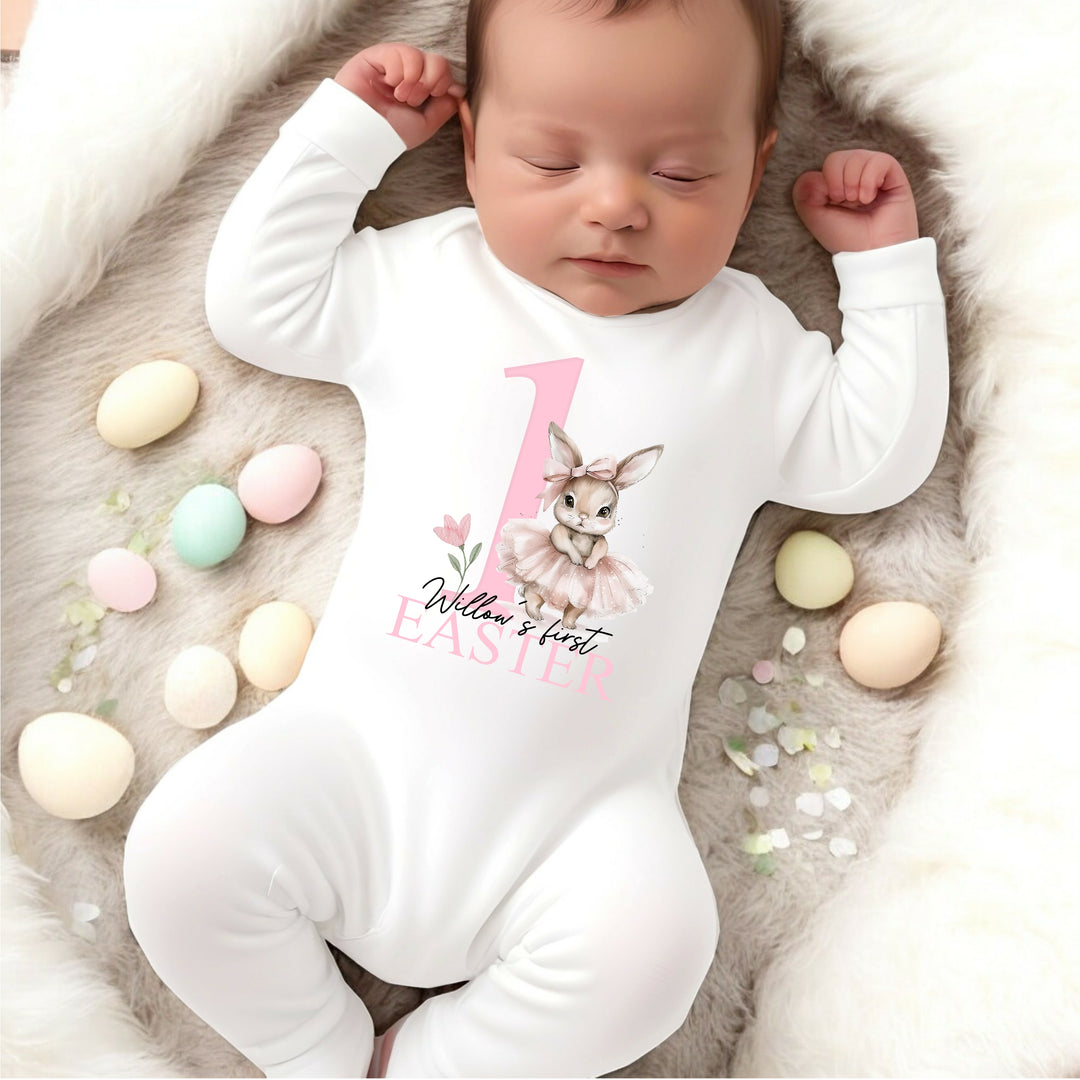 Personalised white Easter baby grow/sleepsuit that says 'Willow's first Easter'. This design features a big pink 1 with a ballerina bunny standing next to it 