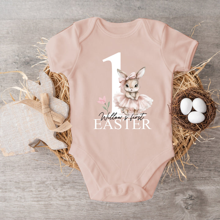 Personalised pink Easter baby vest that says 'Willow's first Easter'. This design features a big pink 1 with a ballerina bunny standing next to it 