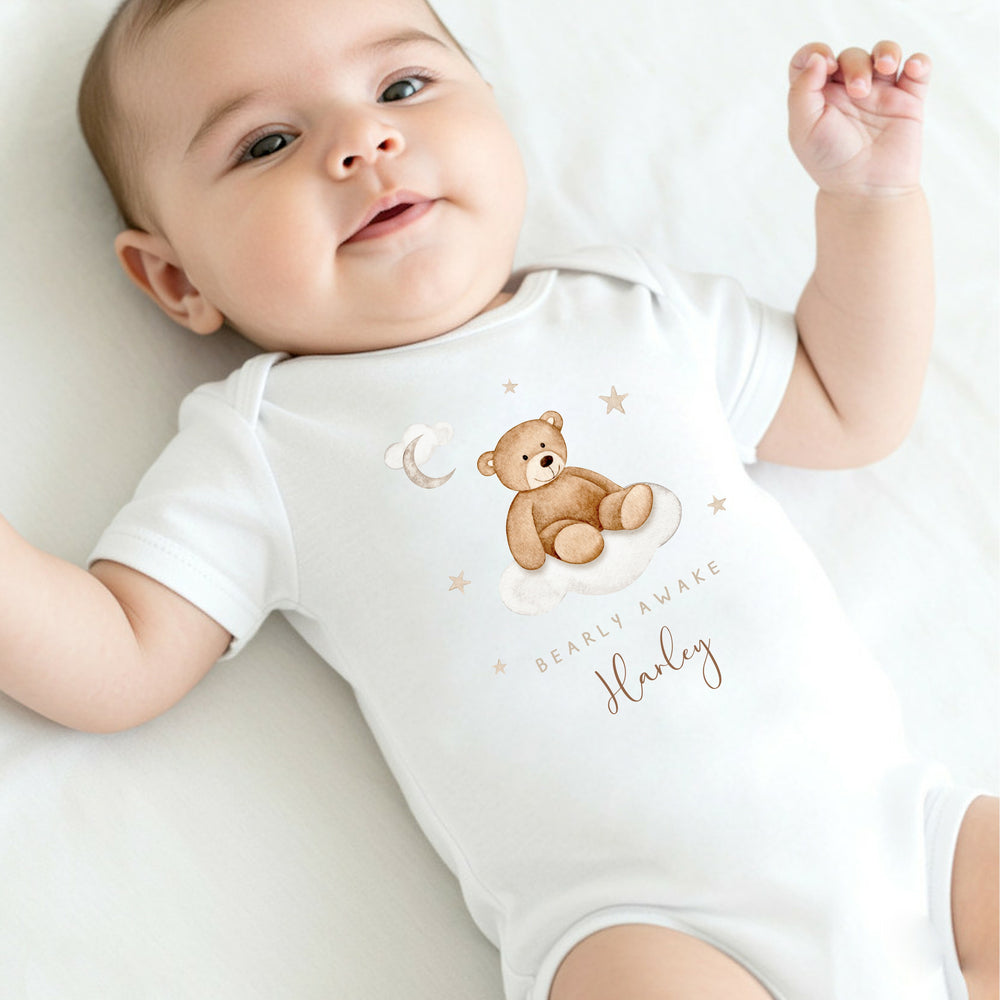A personalised white baby vest that says 'Baarly Awake Harley'. This design features a bear sitting on a cloud