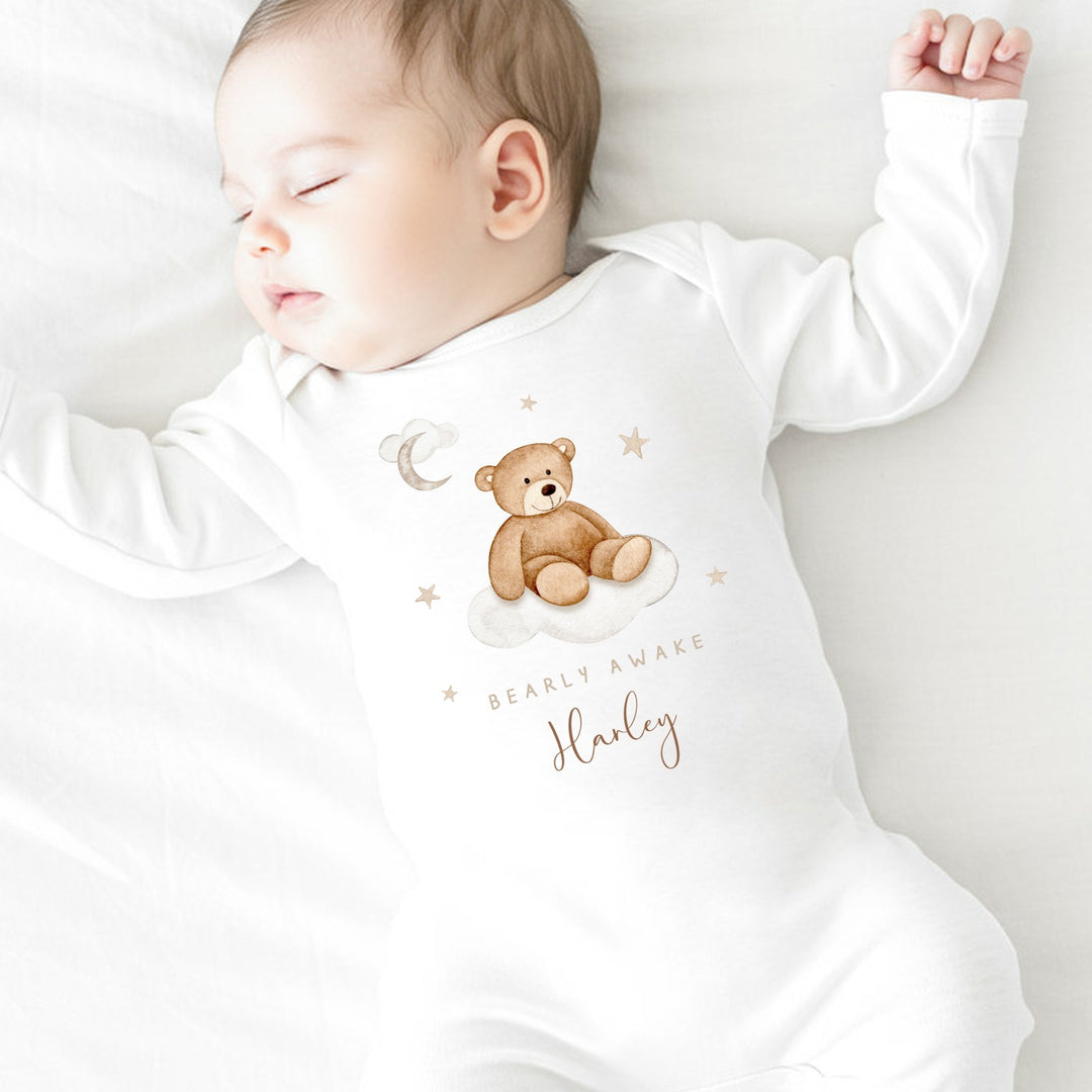 A personalised white baby grow that says 'Baarly Awake Harley'. This design features a bear sitting on a cloud