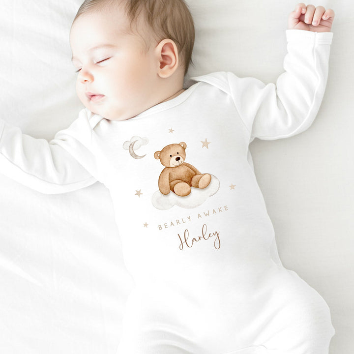 A personalised white baby grow that says 'Baarly Awake Harley'. This design features a bear sitting on a cloud