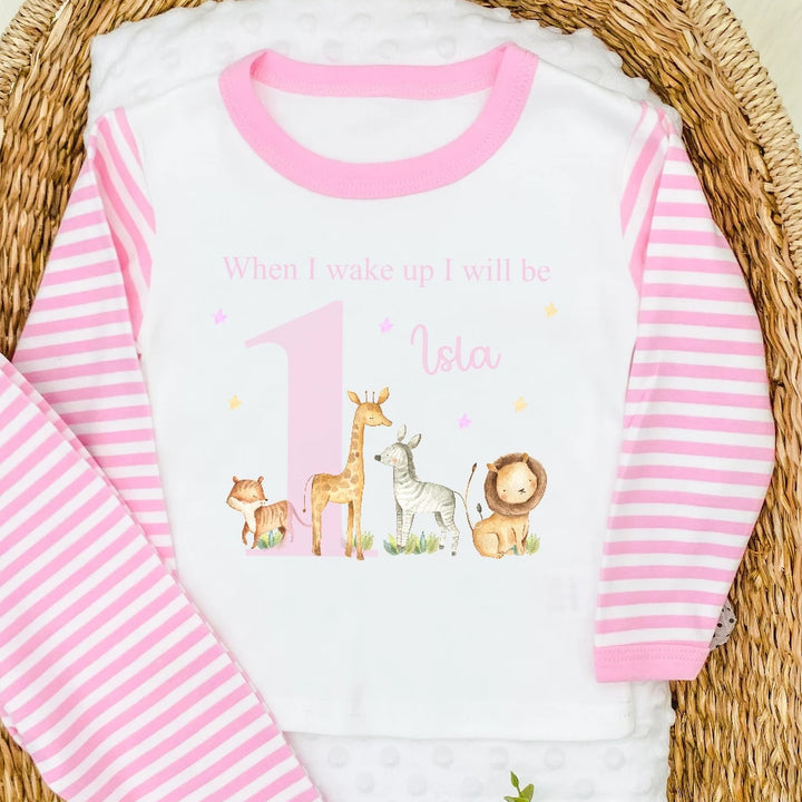 Personalised pink stripe birthday pyjamas that say 'When I wake up I will be 1 Isla'. This design features a big pink 1 with jungle animals around it 