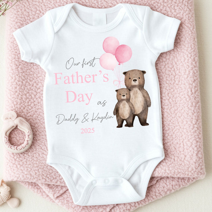 Personalised white Father's Day baby vest that says 'Our First Father's Day as Daddy & Kaydin 2025'. This design features 2 brown bears holding 3 pink balloons