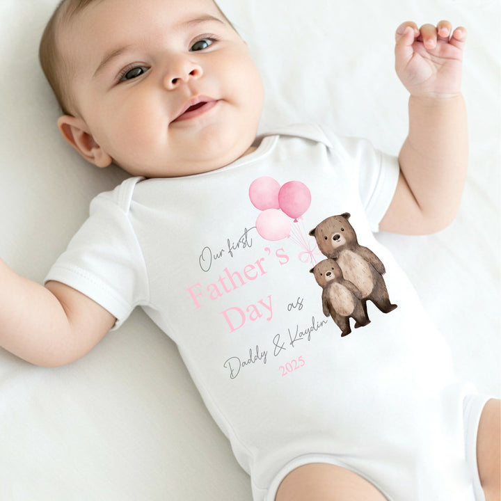 Personalised white Father's Day baby vest that says 'Our First Father's Day as Daddy & Kaydin 2025'. This design features 2 brown bears holding 3 pink balloons