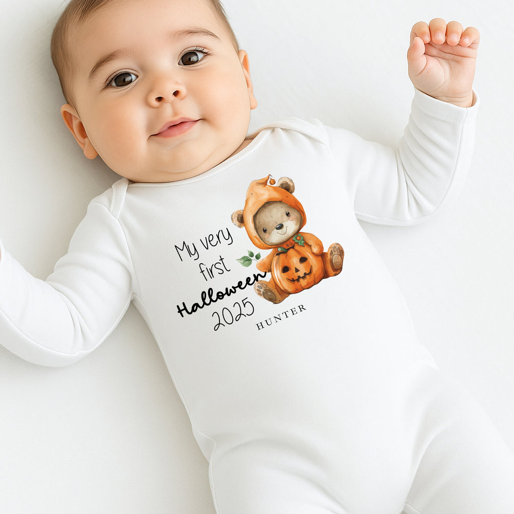 Baby wearing a white onesie with a Halloween design and text.