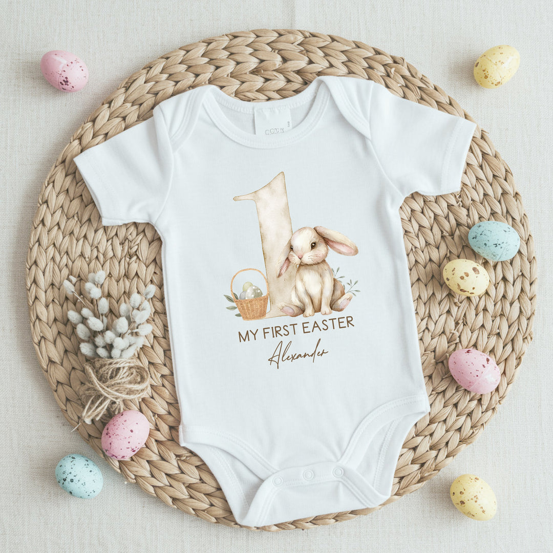 Personalised white Easter Vest that says 'My First Easter Alexander'. This design features a big beige 1 and a brown rabbit and an Easter basket