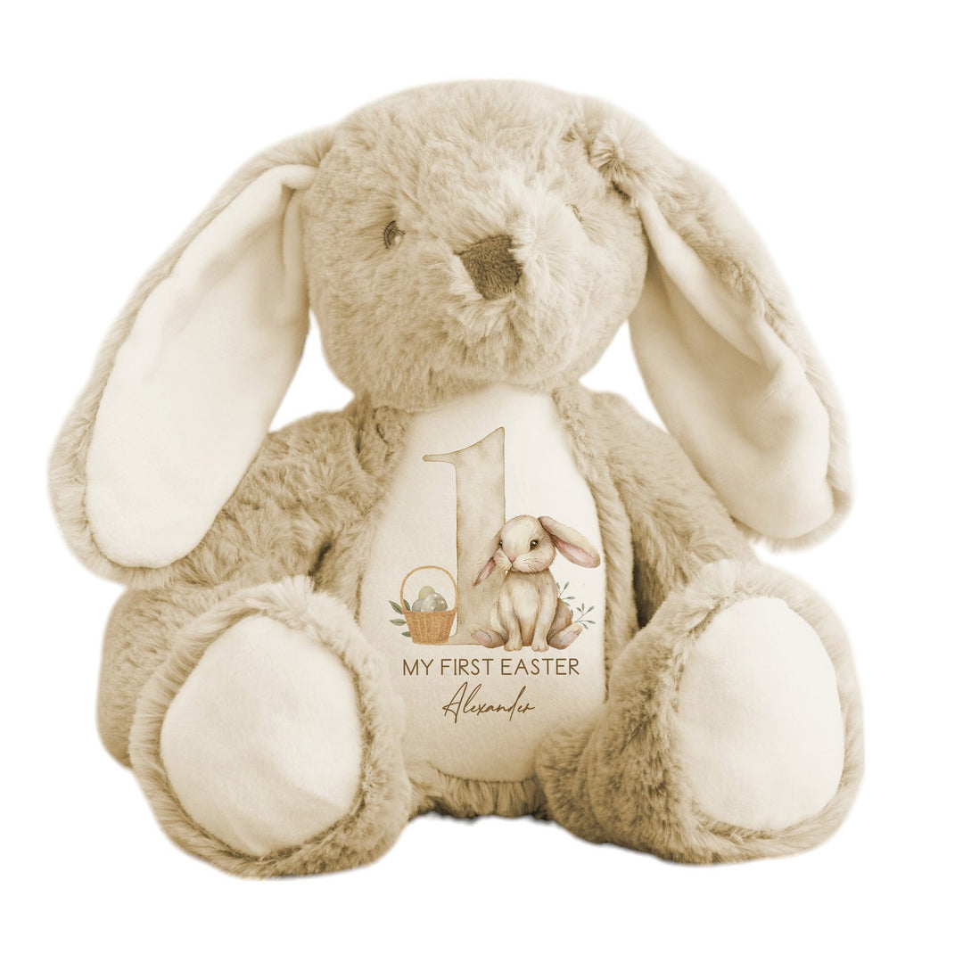 A personalised beige Easter Teddy that says 'My First Easter Alexander'. This design features a big beige 1 with a beige rabbit and Easter basket next to it.