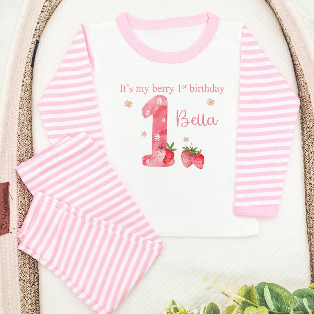 Personalised pink stripe pyjamas that say 'It's my berry 1st birthday 1 Bella' This design features a pink 1 with strawerrys around it 