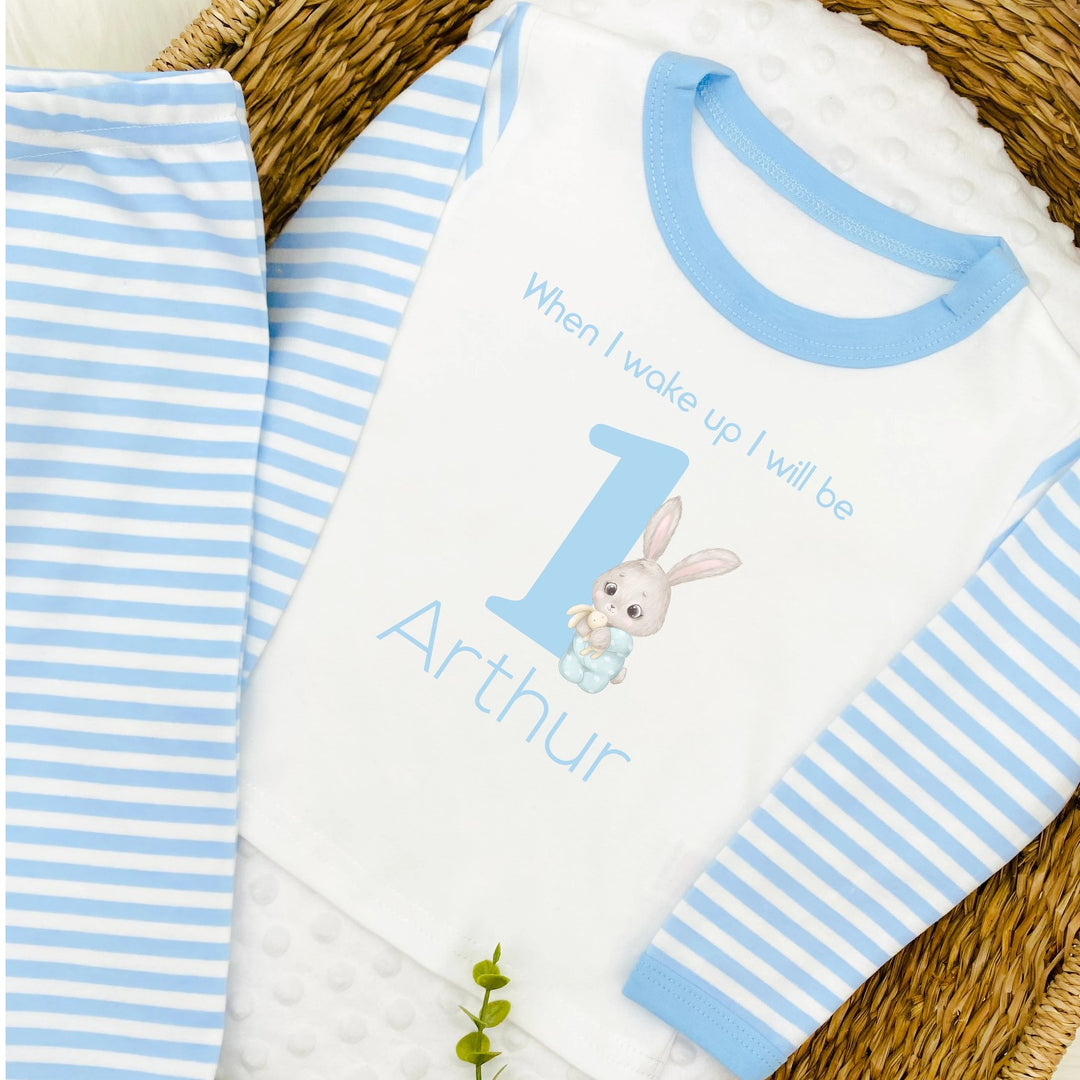 Blue Stripe birthday pyjamas that say 'When I wake up I will be 1 Arthur'. This design features a big blue 1 and a bunny  in blue pyjamas