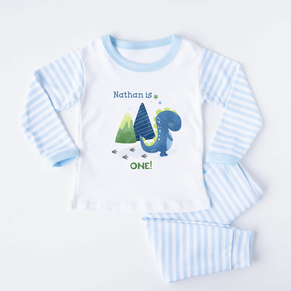 Blue Stripe birthday pyjamas that say 'Nathan is ONE!'. This design features a blue dinosaur