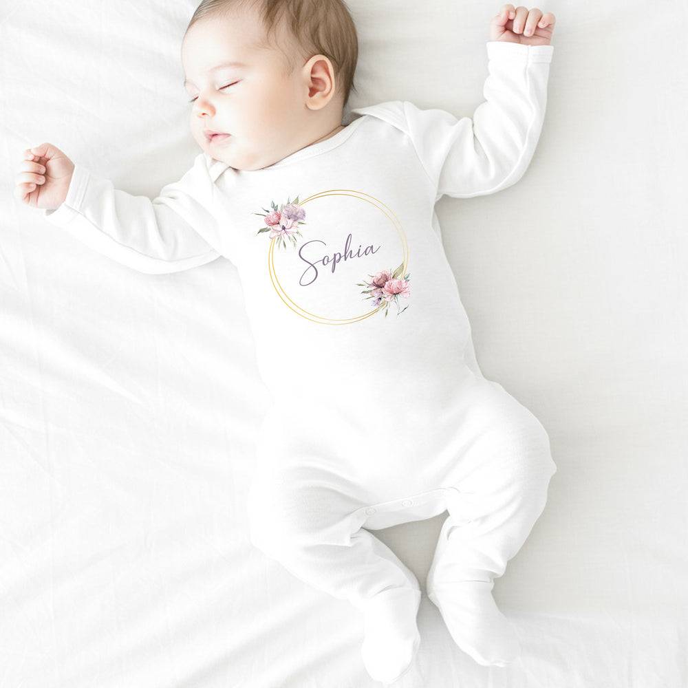 a personalised white baby vest that says 'Sophia'. This design features a purple and pink wreath with a name in the middle of it 