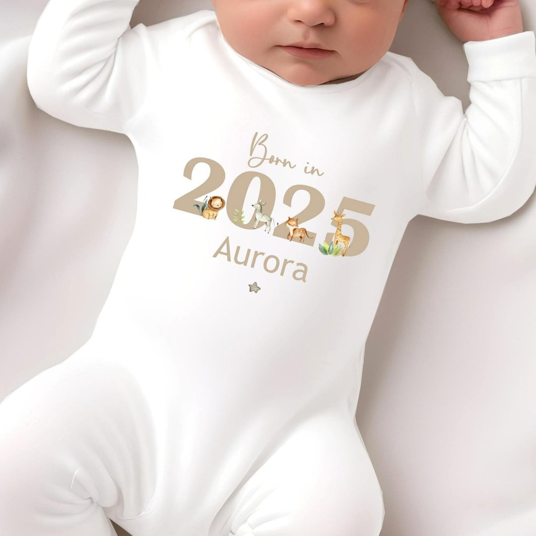 Personalised white baby grow that says 'Born in 2025 Aurora' in beige. This design features safari animals around the 2025