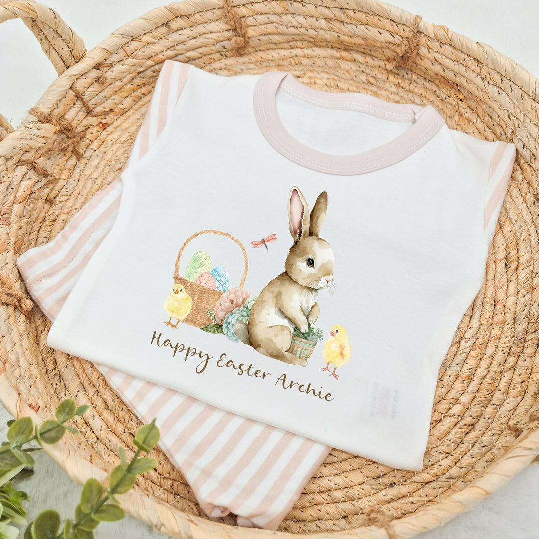 Personalised beige striped Easter Pyjamas that say 'Happy Easter Archie'.  This design features a brown bunny and an easter basket