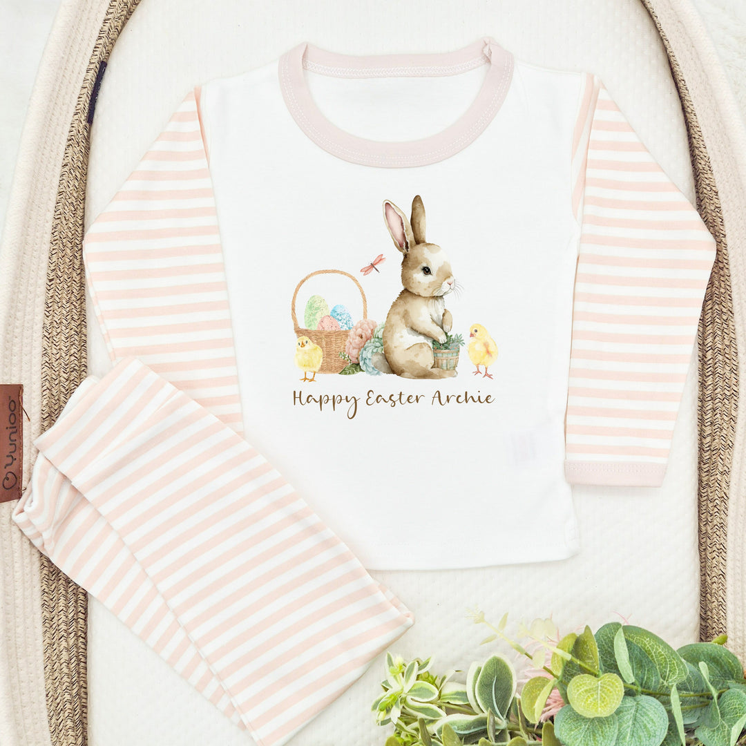 Personalised beige striped Easter Pyjamas that say 'Happy Easter Archie'.  This design features a brown bunny and an easter basket