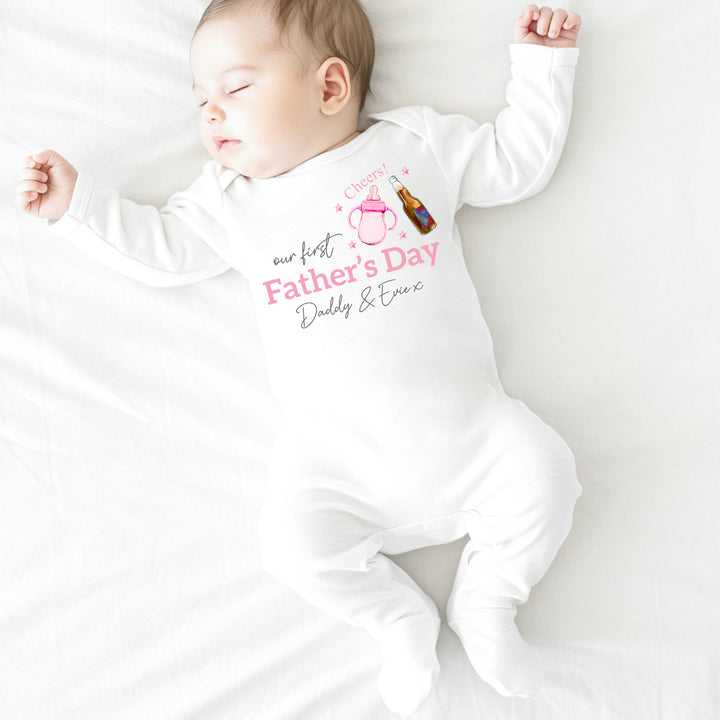 Personalised white Father's Day baby grow/sleepsuit that says 'Our First Father's Day Daddy & Evie x'. This design features a pink bottle of milk with a bottle of beer