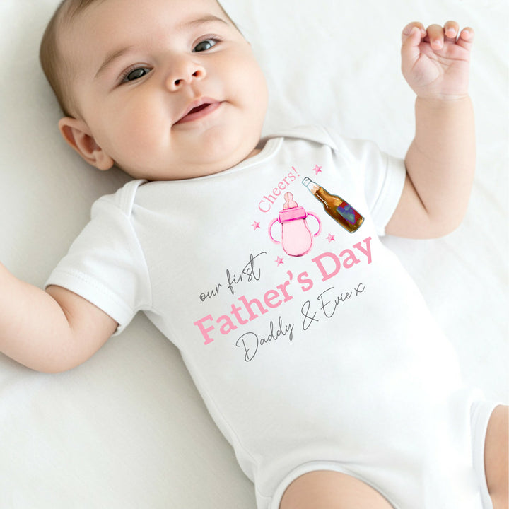 Personalised white Father's Day baby vest that says 'Our First Father's Day Daddy & Evie x'. This design features a pink bottle of milk with a bottle of beer