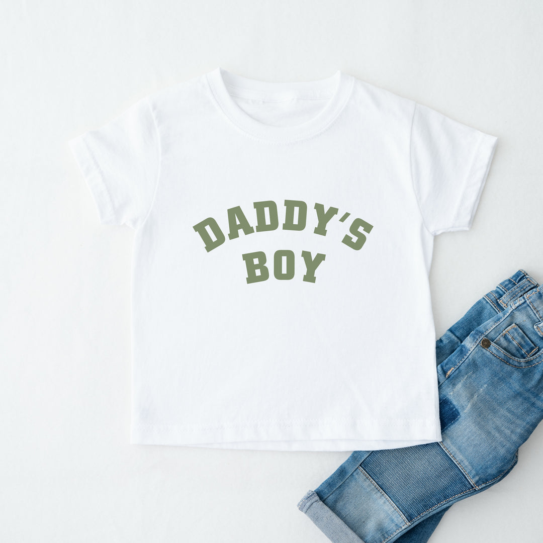 White t-shirt with 'Daddy's Boy' text and blue jeans on a white background