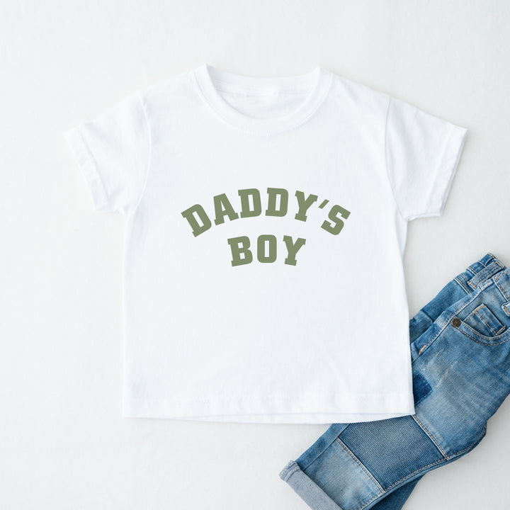 White t-shirt with 'Daddy's Boy' text and blue jeans on a white background