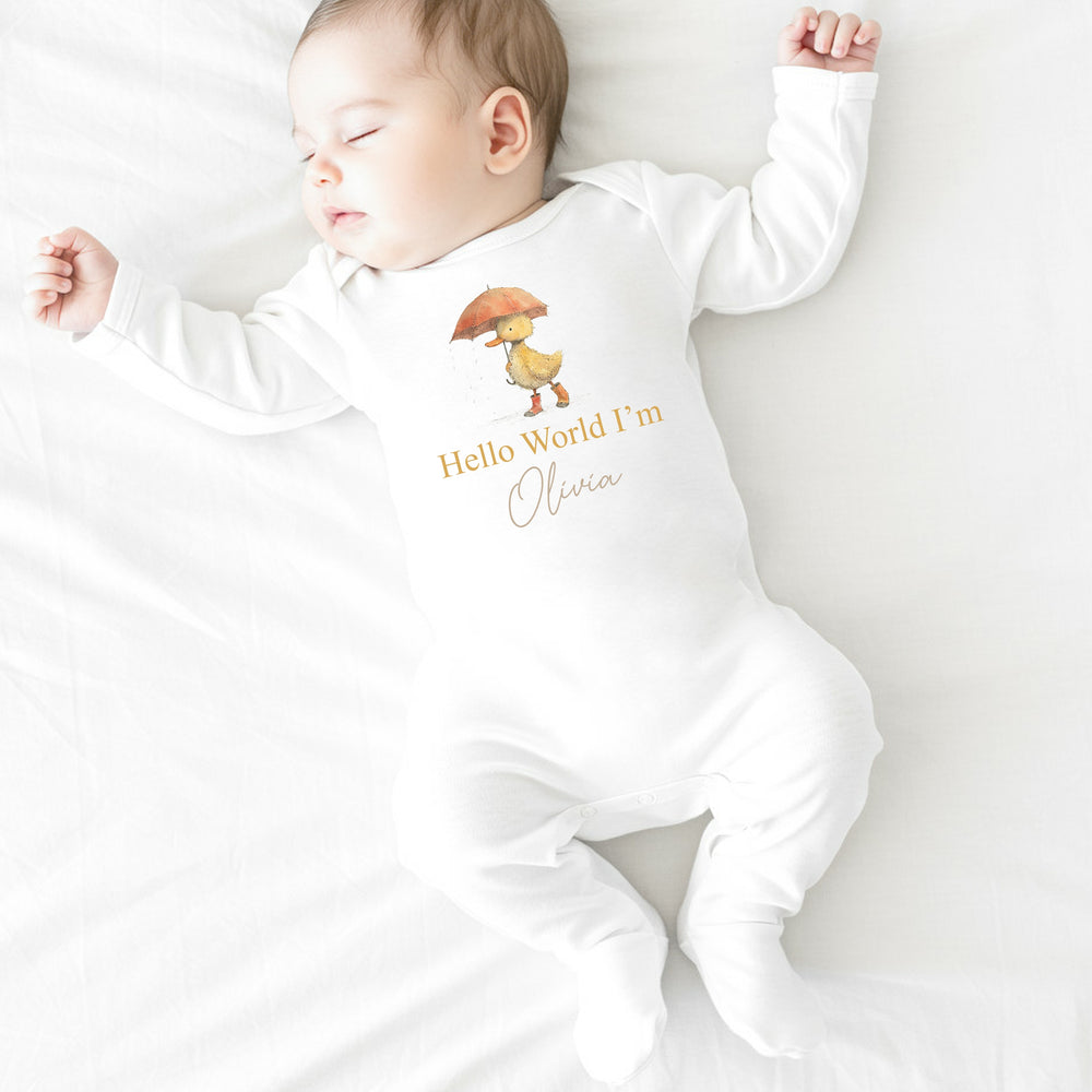 A personalised white baby grow that says 'Hello World I'm Olivia'. This design features a yellow duck holding an orange umbrella