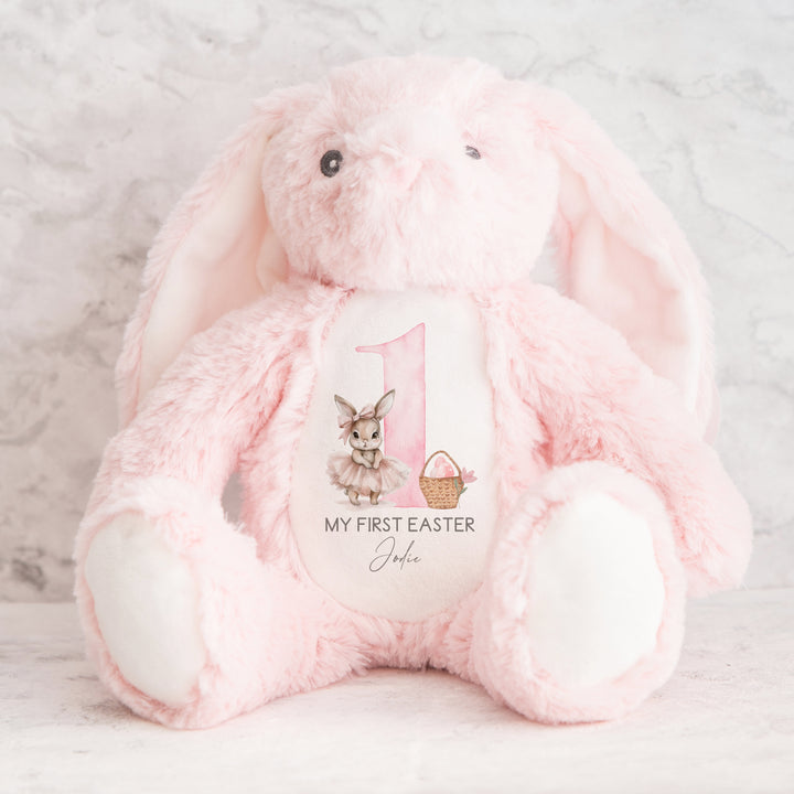 Personalised pink bunny Easter teddy that says 'My First Easter Jodie'. This design features a big pink 1 with a ballerina bunny one side and an Easter basket with pink eggs in it on the other side. 