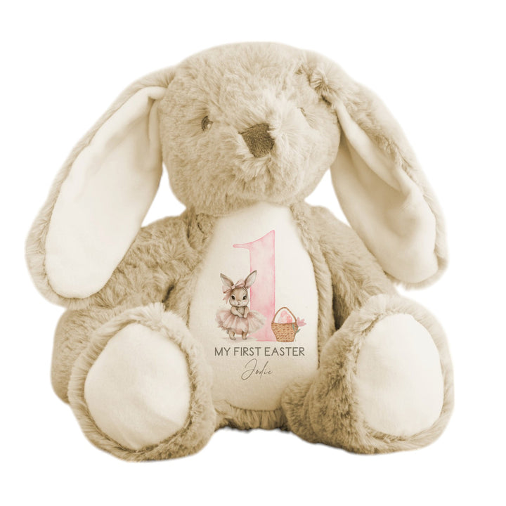 Personalised beige bunny Easter teddy that says 'My First Easter Jodie'. This design features a big pink 1 with a ballerina bunny one side and an Easter basket with pink eggs in it on the other side. 