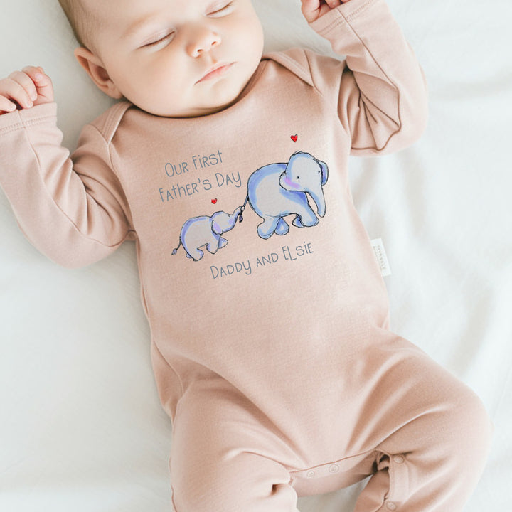 Personalised pink Father's Day baby grow/sleepsuit that says 'Our First Father's Day Daddy & Elsie'. This design features 2 blue elephants