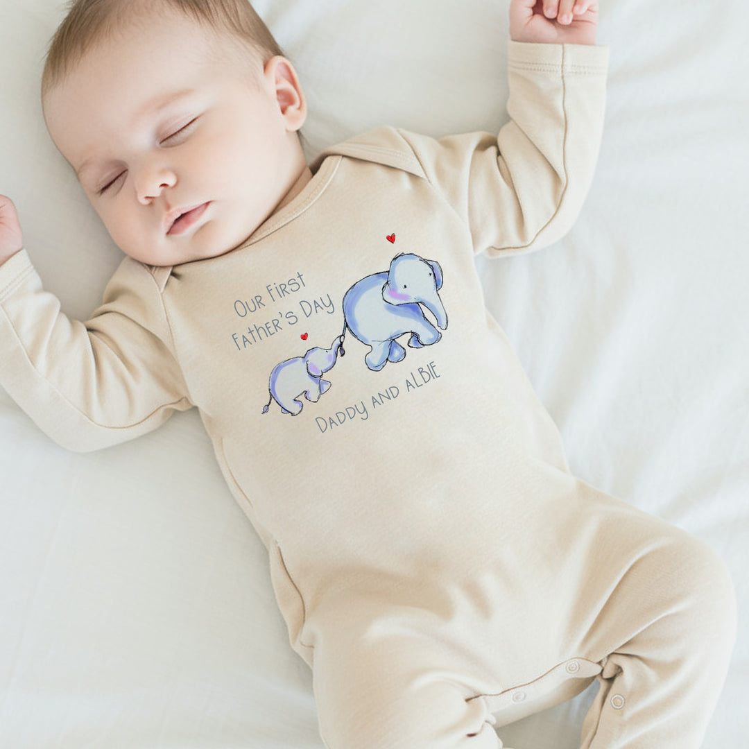 Personalised beige Father's Day baby grow/sleepsuit that says 'Our First Father's Day Daddy & Albie'. This design features 2 blue elephants