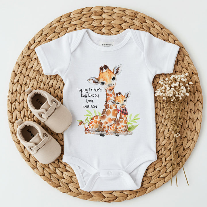 Personalised white Father's Day baby vest that says 'Happy Fathers's Day Daddy Love Harrison'. This design features 2 giraffes, one of which is wearing a bandana