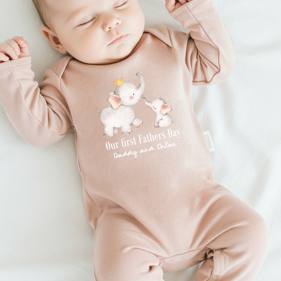 Personalised pink Father's Day baby grow that says 'Our First Fathers Day Daddy and Chloe'. This design features a daddy elephant wearing a crown and a baby elephant