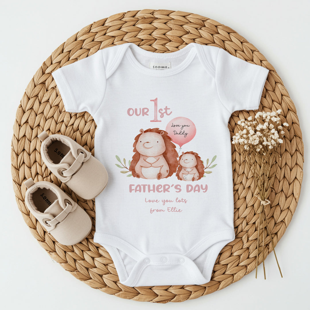 Personalised white Father's Day baby vest that says 'Our 1st Father's Day love you lots from Ellie'. This design features 2 hedgehogs, one of which is holding a balloon that say 'Love you daddy'