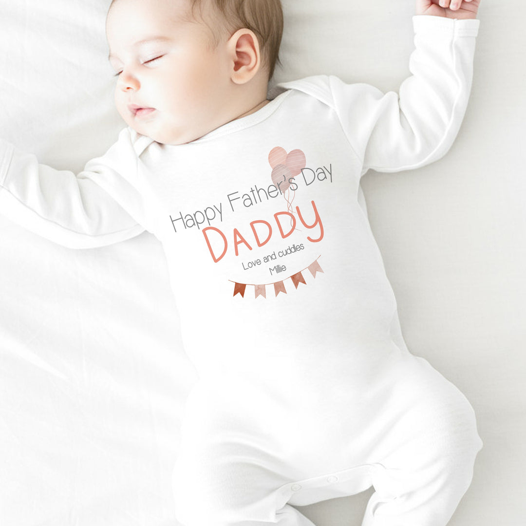 Personalised white Father's Day baby grow/sleepsuit that says 'Happy Father's Day Daddy Love and Cuddle Millie'. This design features a red bunting and balloon