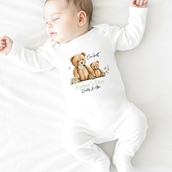 Personalised white Father's Day baby grow/sleepsuit that says 'Our first Father's Day Daddy & Albie'. This design features a big teddy bear wearing a sage green bow tie sitting next to a little teddy bear